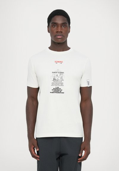 Camiseta de algodón blanca con un estampado gráfico que incluye texto. Logo "ICEBERG" en rojo en la parte superior. Mangas cortas y una etiqueta en la manga izquierda.