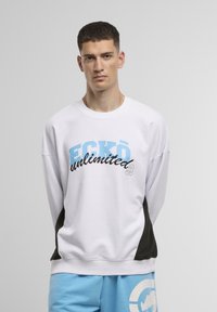 Felpa bianca con accenti neri ai lati, con la scritta "ECKŌ unlimited" in blu e nero sulla parte anteriore. Vestibilità comoda, design casual.