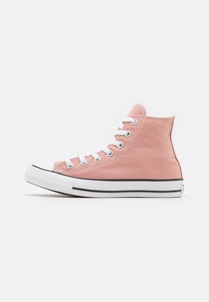 Zapatilla de lona alta rosa con cordones blancos, puntera de goma y franja negra en la suela. Material de algodón con una textura suave.