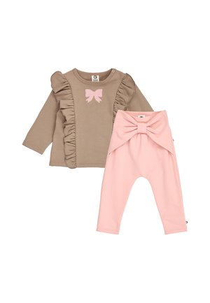 Beige langærmet babytop med flæser og lyserød sløjfe, parret med lyserøde bukser med stor sløjfe i taljen.