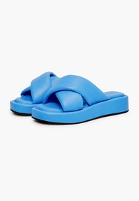 Modré skládací sandály vyrobené z měkkého syntetického materiálu; obsahují design křížových popruhů, polstrovanou stélku a zvýšenou podrážku pro oporu.