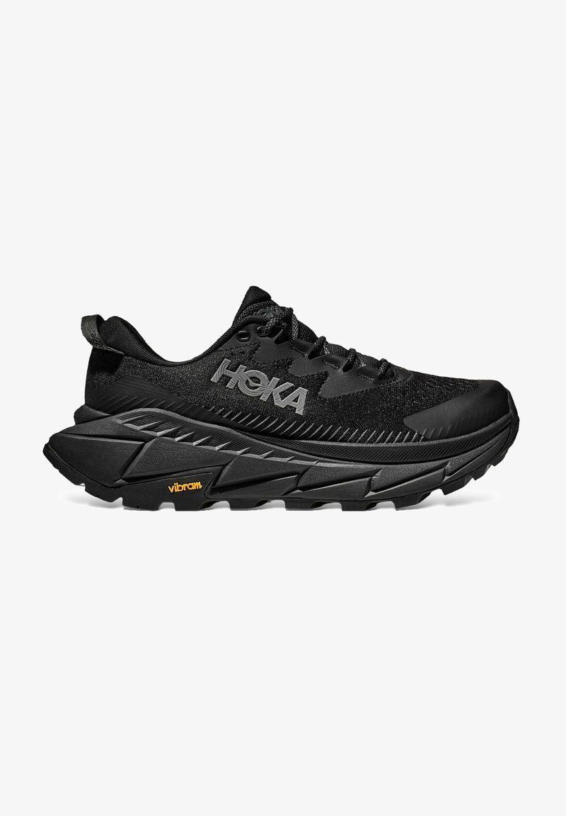 Black HOKA running shoes featuring a textured mesh upper, thick cushioned sole, Vibram outsole, and laces for a secure fit.