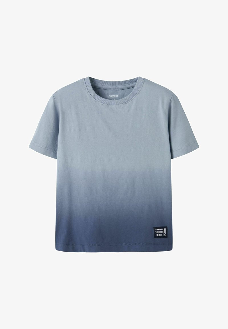 T-shirt à manches courtes et col rond avec un dégradé bleu clair à foncé et un petit patch "Shikoku Beach" en bas à droite.