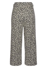 Högmidjade byxor med vida ben i ett svart och beige oregelbundet prickmönster, med en knapp och bältesöglor på midjan.