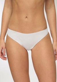 Slip in cotone bianco con una texture liscia, design a vita bassa e cuciture minime per comfort e una silhouette pulita.