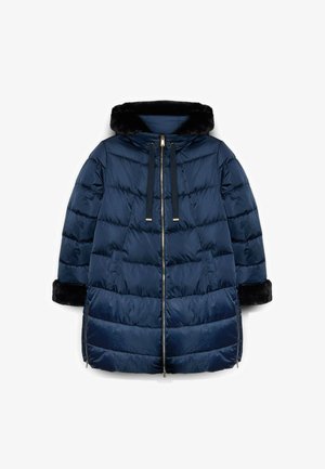 Granatowa kurtka puchowa z kapturem wyłożonym sztucznym futrem, zapinana na zamek, z trokami i ściągaczami na rękawach. Posiada pikowany wzór oraz boczne kieszenie.