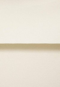 Geribbelde, gestructureerde stof in gebroken wit, met een gladde oppervlakte en subtiele glans, gevouwen aan de bovenkant, wat de zachte structuur benadrukt.