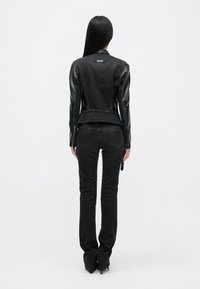 Musthave mustripsiga must denimpuhv, millel on nahkvarrukad, läikiv disain ja peplum talje. Kombineeritud mustade slim-fit teksade ja kontsakingadega.