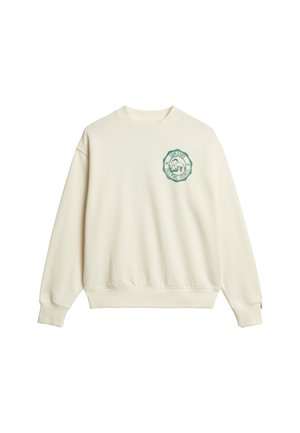 Sudadera color crema con cuello redondo, puños y cinturilla acanalados. Presenta un logo bordado en verde en el lado izquierdo del pecho.