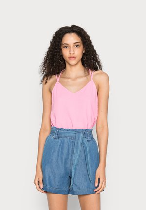 Top rosa sem mangas com alças finas e decote em V, combinado com calções de ganga de cintura alta com um cinto atado e bainha desfiada.