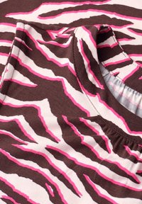 Tissu sans manches avec motif rayures zèbre marron, blanc et rose, détail de l'encolure froncée et vue rapprochée des coutures et de la texture.