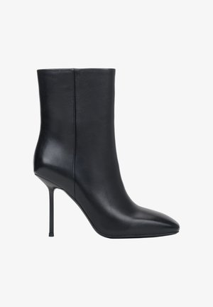Czarny skórzany botek za kostkę z ostrym noskiem i cienkim szpilkowym obcasem, gładka faktura, widok z boku na białym tle.