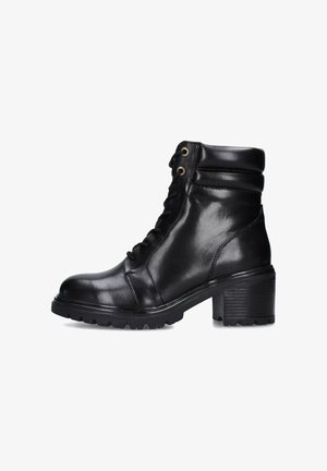 Stivale alla caviglia in pelle nera con punta arrotondata, lacci anteriori, collare imbottito e tacco spesso e testurizzato. La suola presenta una scolpitura robusta.