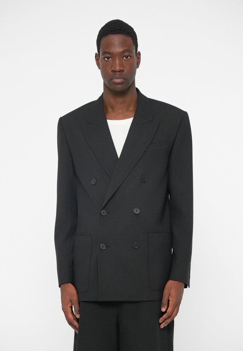 Sort dobbeltbrystet blazer med klippet revers, to forlommer og seks knapper. Fremstillet af tekstureret stof, designet i en løs pasform.