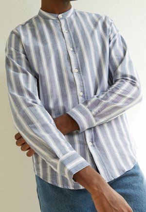 Camisa ligera de manga larga con cuello de banda, presenta rayas verticales en azul y blanco. Se aprecian los botones en la parte delantera y en los puños.