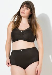 Reggiseno nero, tessuto testurizzato con un design strutturato, caratterizzato da un dettaglio a fiocco al centro. Slip nero a vita alta con una finitura liscia e dettaglio con bottoni.