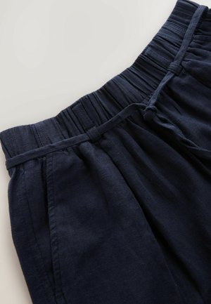 Navy blue linen shorts with an elastic waistband and drawstring. Features side pockets and a relaxed fit, highlighting a soft, textured fabric.