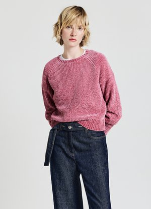 Rosa strukturierte Strickjacke mit weitem Ausschnitt und ribbelndem Saum, getragen über dunkelblauen, hoch taillierten Jeans.