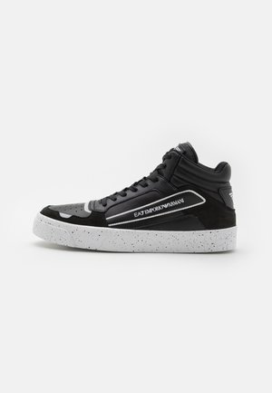 Sort højtop-sneaker med hvidsprættet sål, "EA7 Emporio Armani"-logo på siden og polstret ankelkrave på ensfarvet baggrund.