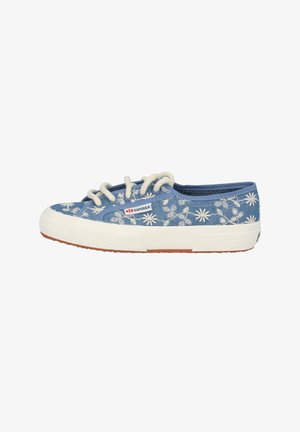 Blue canvas sneaker with white floral embroidery, round toe, beige rubber sole, and white laces. Features a logo patch on the side.