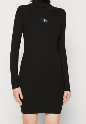 Zwart geribd gebreide mini-jurk met lange mouwen en coltrui, met een klein rechthoekig Calvin Klein Jeans-logo op de borst.