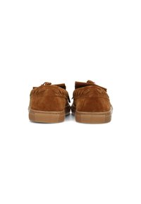 Mocasines de ante marrón con costuras decorativas y detalle de flecos. Las suelas de goma son de un marrón claro. Diseño minimalista, vista trasera.
