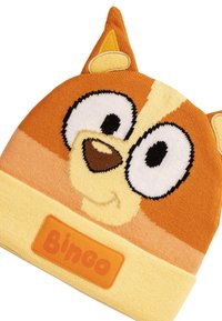 Beanie lavorato a maglia in arancione e giallo con il volto di un personaggio dei cartoni animati, con occhi sovradimensionati, un naso e orecchie a punta. Etichetta "Bingo" in basso.