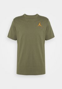 Olive green cotton t-shirt featuring a crew neck, short sleeves, and an orange embroidered Jumpman logo on the left chest area.