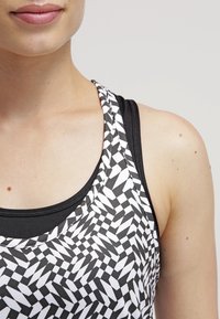 Zwart-wit gestreepte tanktop met een geometrisch ontwerp, met een slim fit, dunne bandjes en een gladde stoftextuur.