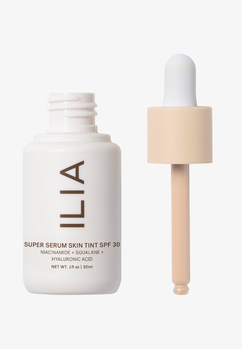Sérum teinté super ILIA SPF 30 dans un flacon blanc avec du texte marron, doté d'un compte-gouttes beige pour doser le liquide. Capacité de 30 ml.