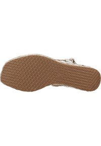 Suela de goma marrón con un patrón geométrico texturizado, que presenta triángulos elevados y un logotipo. Diseño ligero y flexible.