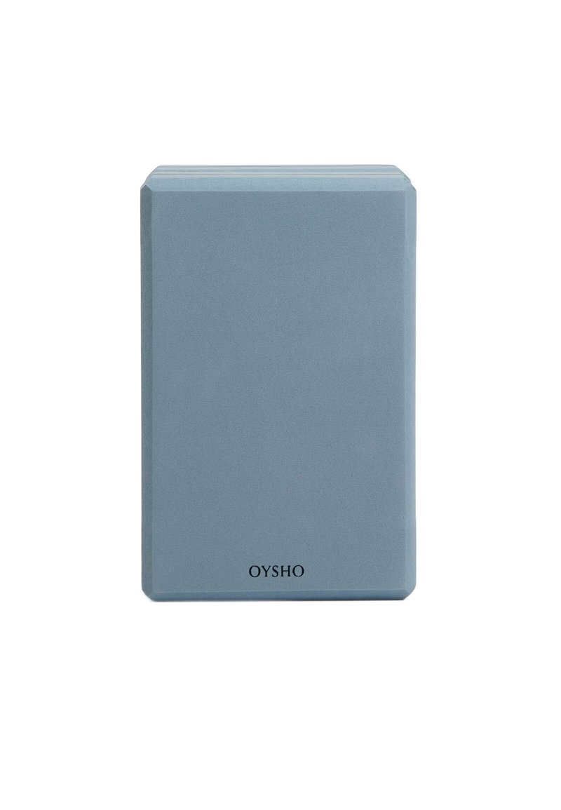 Brique de yoga rectangulaire bleu clair en mousse dense. Texture lisse avec des bords arrondis, arborant le nom de la marque "OYSHO" en bas.