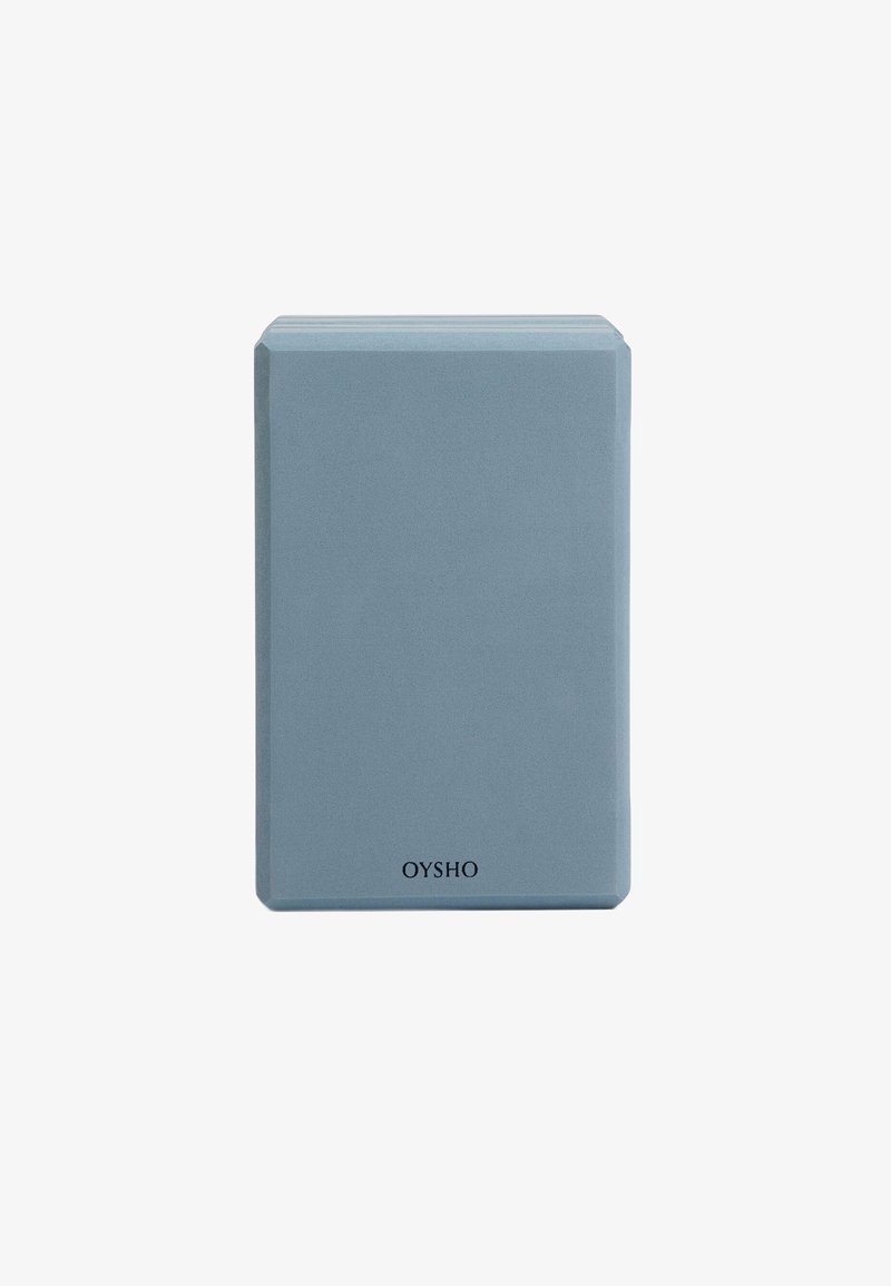 Brique de yoga rectangulaire bleu clair en mousse dense. Texture lisse avec des bords arrondis, arborant le nom de la marque "OYSHO" en bas.