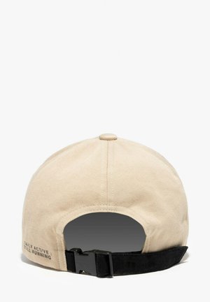 Beige baseballpet met een zwarte verstelbare band en gesp, tekst "DAILY ACTIVE STILL RUNNING" gedrukt nabij de band aan de linkerkant van de achterkant.
