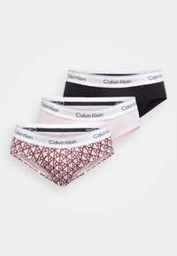 Trzy pary majtek Calvin Klein: czarne, jasnoróżowe oraz różowe w wzory z czerwonymi elementami, wszystkie z białymi gumkami z logo marki.