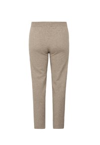 Spodnie w jasnym beżu, miękka tkanina, slim fit, elastyczny pas, zwężane nogawki, brak widocznych szwów ani elementów metalowych, gładka faktura.