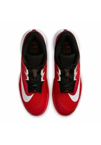 Zapatillas atléticas rojas con un upper texturizado, cordones negros y un destacado logo de swoosh blanco en el lateral. La suela es blanca con un diseño estampado.