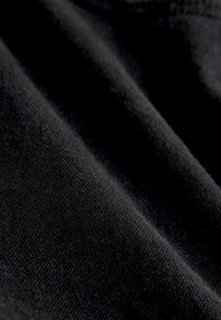 Schwarzer Stoff mit glatter Textur, der ein feines Webmuster aufweist. Das Material wirkt weich und leicht reflektierend, mit dezenten Falten.