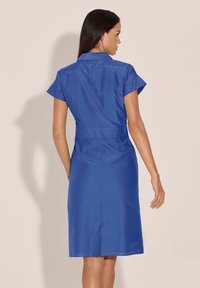 Blaues, kurzärmeliges Kleid mit Kragen, Taillengürtel und Rückennahtdetails. Glatte Textur, taillierte Passform und knielanges Design.