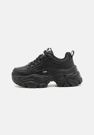 Black athletic sneakers with a chunky rubber sole, padded collar, and lace-up design. Made of synthetic leather with subtle logo accents.