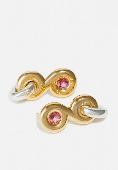 Orecchini in oro e argento a forma di simbolo dell'infinito, con due gemme rosa. Finitura metallica liscia con un design intrecciato.