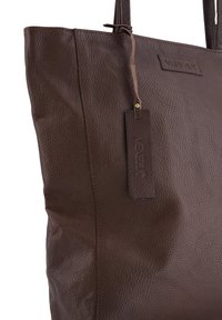 Braune Ledertasche mit strukturierter Oberfläche, rechteckiger Form und einem angehängten Markenetikett, ausgestattet mit zwei stabilen Griffen.