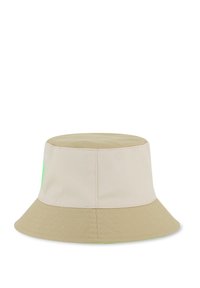 Cappello a secchiello beige con tesa larga, realizzato in tessuto strutturato. Presenta un emblema verde sul lato. Corona liscia con cima piatta.