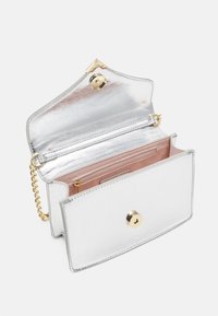 Silver metallic mini purse with a shiny finish, featuring a gold snap closure and a pink interior. Includes a chain strap for versatility.