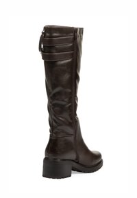 Bota alta hasta la rodilla de cuero sintético marrón con cremallera lateral, superficie texturizada, tacón apilado y tres correas horizontales en la parte superior.