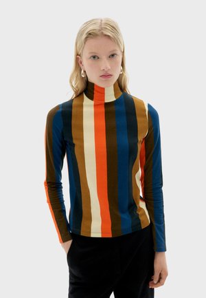 Multicolored turtleneck top featuring vertical stripes in brown, blue, red, and cream colors. Long sleeves, soft fabric, fitted design.