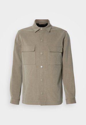 Bež jakna s dugim rukavima i ovratnikom, s dva džepa na prsima i metalnim kopčama, izrađena od teksturiranog materijala.