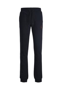 Tmavě modré tepláky vyrobené z měkké tkaniny, s elastickým pasem na stahování, žebrovanými manžetami a logem na levé noze.