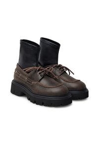 Stivali alti in pelle marrone e sintetico nero con suola nera spessa, caratterizzati da lacci frontali e dettagli di cucitura.