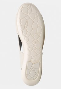 Suola della scarpa in beige chiaro con un motivo a nido d'ape testurizzato. Branding sottile visibile. Contorni lisci e costruzione resistente evidenti.